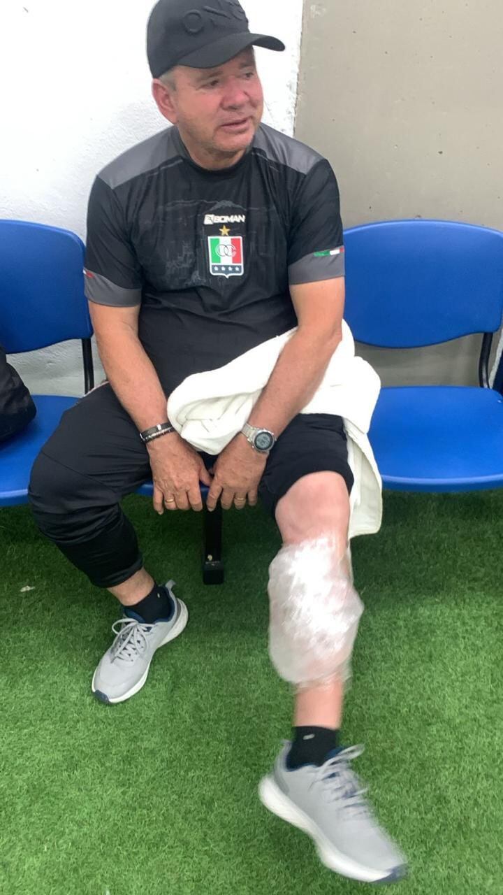 El entrenador del Once Caldas, Hernán Dario Herrera, tuvo que ser atendido por los médicos del plantel por un golpe en su pierna durante los disturbios - crédito redes sociales