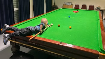 Jude Owens ejecutando una jugada de snooker en una mesa profesional