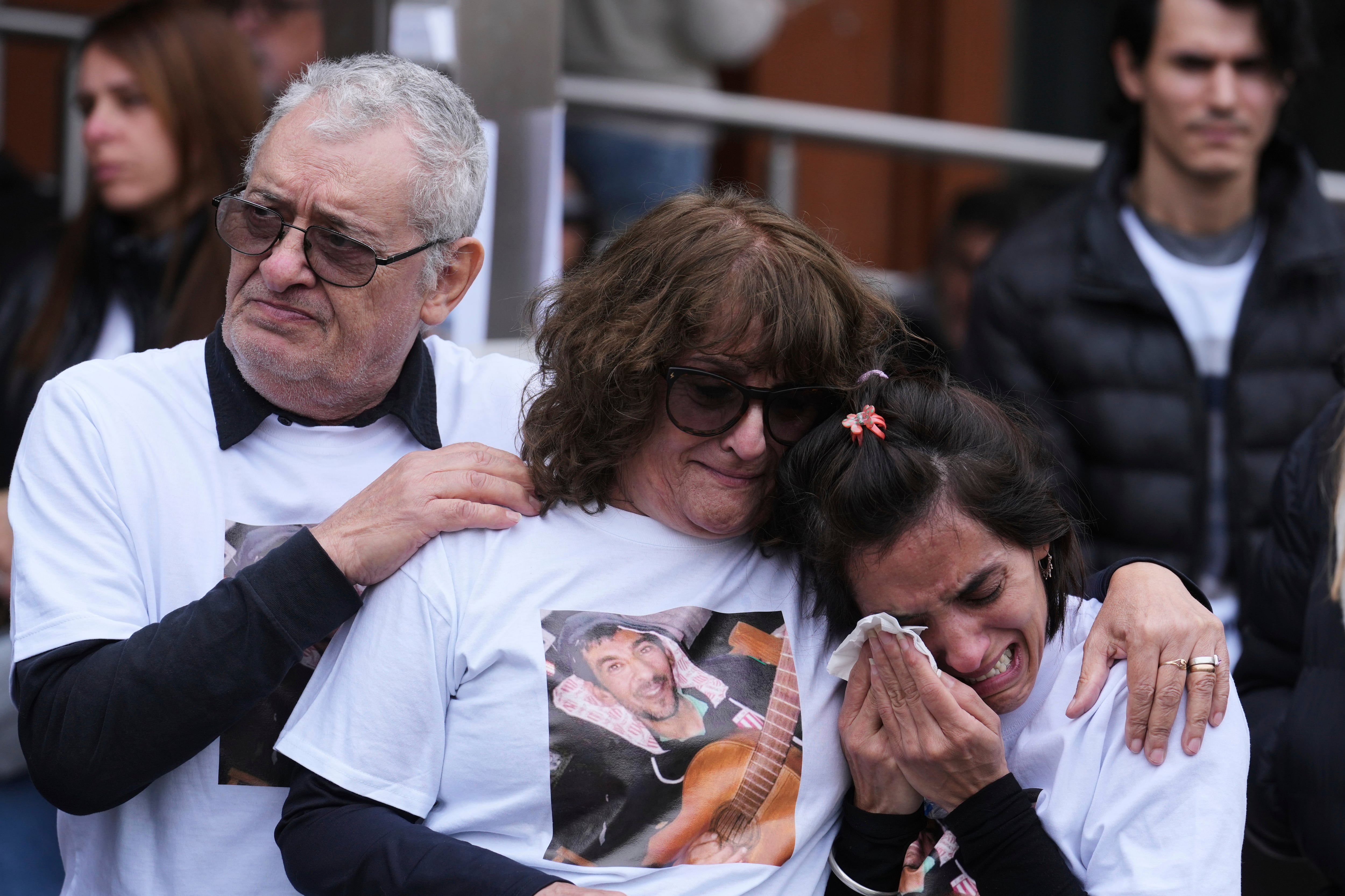 Familiares de Daniel Sebastián Oviedo, de izquierda a derecha, su padre Daniel Oviedo, su madre Sandra Altamirano y su hermana Gisel Oviedo, se abrazan afuera del Hospital Italiano durante una protesta exigiendo justicia para él y otras víctimas que murieron después de recibir fentanilo contaminado (AP Foto/Gustavo Garello)