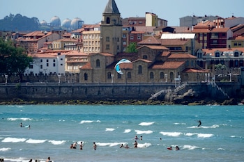 Bañistas en la playa de San Lorenzo de Gijón, a 23 de mayo de 2026. (EFE/ Paco Paredes)