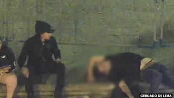Tres personas, una de ellas borrosa, sentadas en un muro bajo en un entorno oscuro. Detrás se aprecia una reja verde. Un recuadro dice CERCADO DE LIMA