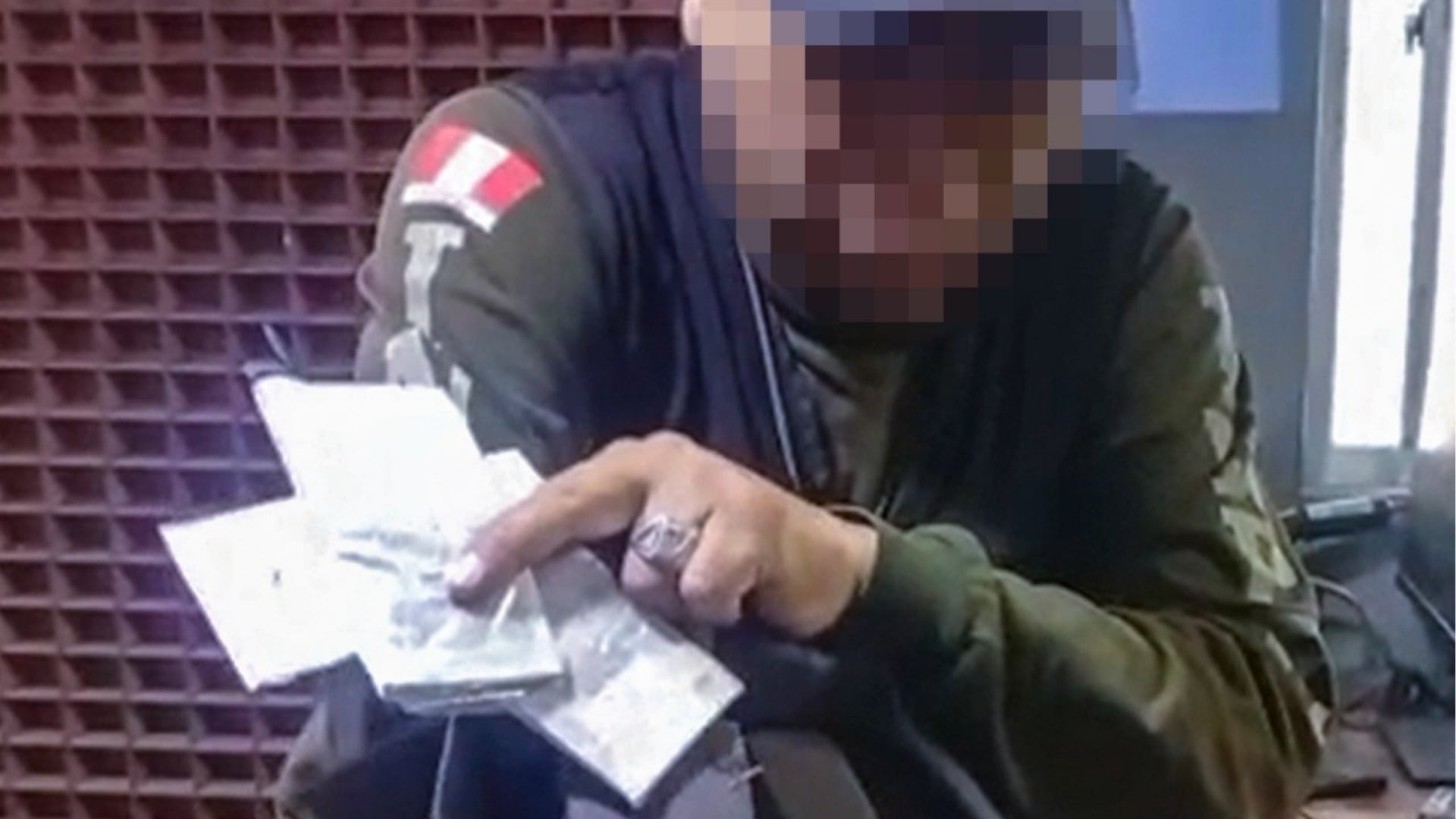 El agente penitenciario Nelson Carrillo muestra los paquetes con dinero y chips incautados durante su detención en el penal de varones de Arequipa. (X/@INPE)
