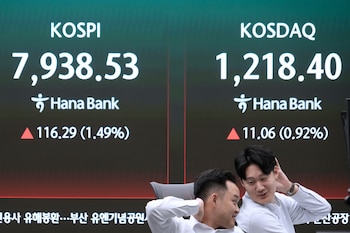 Operadores de divisas reaccionan junto a una pantalla con el índice surcoreano Korea Composite Stock Price Index (KOSPI), a la izquierda, en la sala de operaciones del banco Hana en Seúl, Corea del Sur, el martes 12 de mayo de 2026. (AP Foto/Ahn Young-joon)