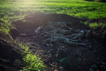 Los cuerpos de los soldados rusos se ven en una tumba en la aldea de Vilkhivka después de que fue retomada por las Fuerzas Armadas de Ucrania, en la región de Kharkiv, Ucrania, el 9 de mayo de 2022. (REUTERS/Julia Kochetova)