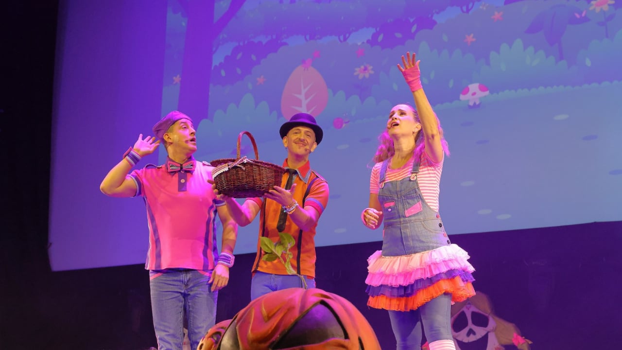 Nacho Bombín, Emi Bombón y Belén Pelo de Oro, integrantes del trío Pica Pica, presentan su espectáculo infantil sobre un escenario en Lima.