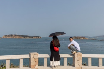 ARCHIVO: Personas están de pie en una plataforma de observación con vistas al estrecho de Taiwán en la isla de Pingtan, provincia de Fujian, China, el 10 de abril de 2023 (Reuters)