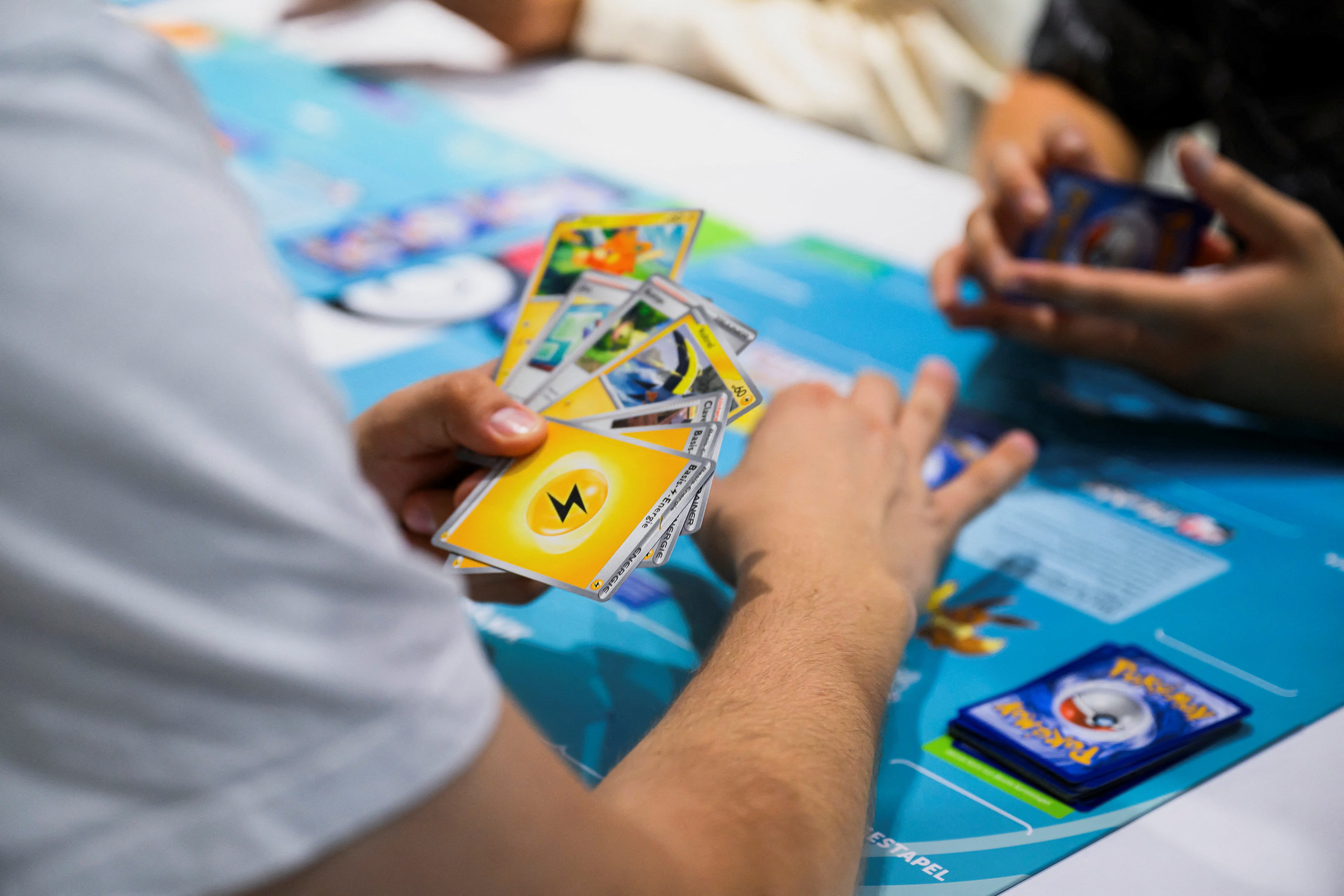 Visitors play the card game Pokemon during the 2024 Gamescom computer and video game industry event in Cologne, Germany, August 21, 2024. REUTERS/Jana Rodenbusch