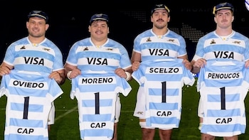 Cuatro hombres con la camiseta argentina de rugby sostienen camisetas impresas con los apellidos Oviedo, Moreno, Scelzo y Penoucos