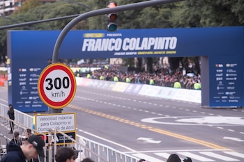 Señal de límite de 300 km/h en primer plano. Al fondo, un arco azul dice "Franco Colapinto Road Show Buenos Aires 2026" con público y una calle vacía