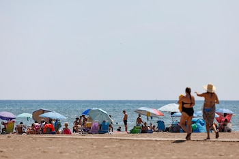 Bañistas disfrutan de la playa de la Patacona de Alboraia, Valencia, a16 de agosto de 2026. (EFE/Manuel Bruque)