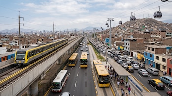 Un tren eléctrico en vía elevada, buses amarillos en una avenida con tráfico y cabinas de teleférico sobre un cerro con viviendas