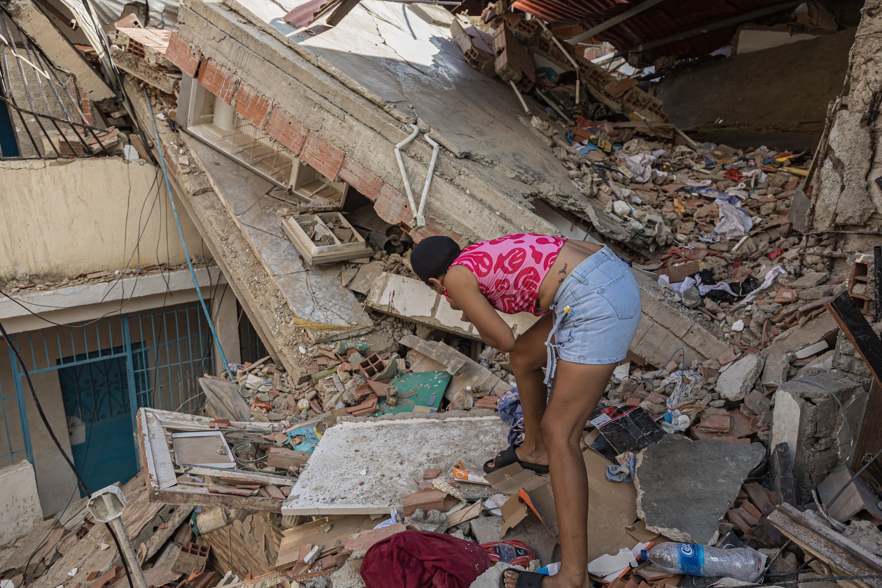 Una mujer busca entre los escombros de las edificaciones destruidas por los terremotos en Catia La Mar (EFE/ Henry Chirinos)