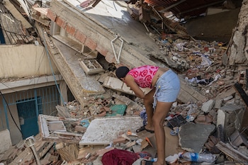 Una mujer busca entre los escombros de las edificaciones destruidas por los terremotos en Catia La Mar (EFE/ Henry Chirinos)