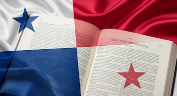Libro abierto con texto en español que dice Constitución Política, sobre el cual se superpone la bandera de Panamá con sus estrellas azul y roja.