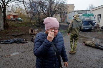Una mujer junto a cuerpos