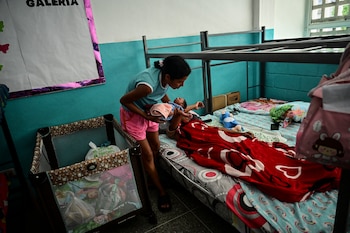 Scarlett Goitia sostiene al bebé de su hermana Eliana García —quien dio a luz tras los terremotos (Martin Bernetti/AFP)