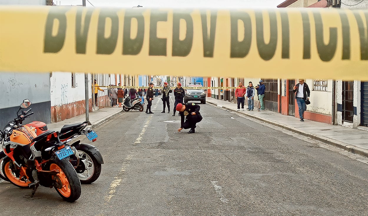 Policías cercan una escena del crimen en una calle de La Libertad, donde asesinaron a balazos a una persona que se negó a ceder al cobro de cupos. (Yolanda Goicochea/La República)