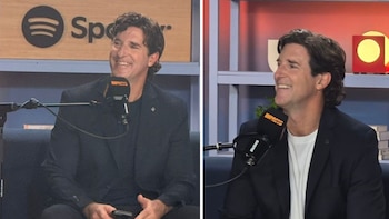 Un hombre sonriente de cabello oscuro sentado en un sofá, con un micrófono de podcast en primer plano y el logo de Spotify en el fondo