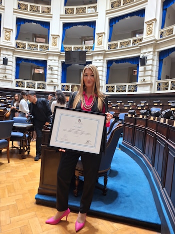 Carina Rodriguez, periodista agropecuaria, recibiendo un reconocimiento en la Legislatura bonaerense