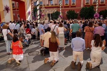 Fieles arrodillados al paso de