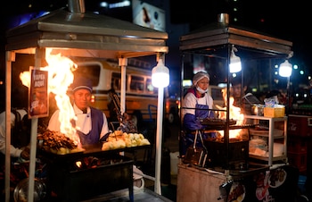 Vendedores ambulantes preparan "Anticucho", un