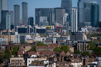 Residential properties stand in view of skyscrapers in the Canary Wharf business, financial and shopping district of London, U.K., on Tuesday, April 21, 2020. U.K. real estate agents called for help from the government as expectations for prices and market activity plunged. Photographer: Chris J. Ratcliffe/Bloomberg