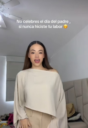 Mujer con blusa y pantalón claros. Texto superpuesto: "No celebres el día del padre, si nunca hiciste tu labor". Fondo con ventilador de techo y cabecero