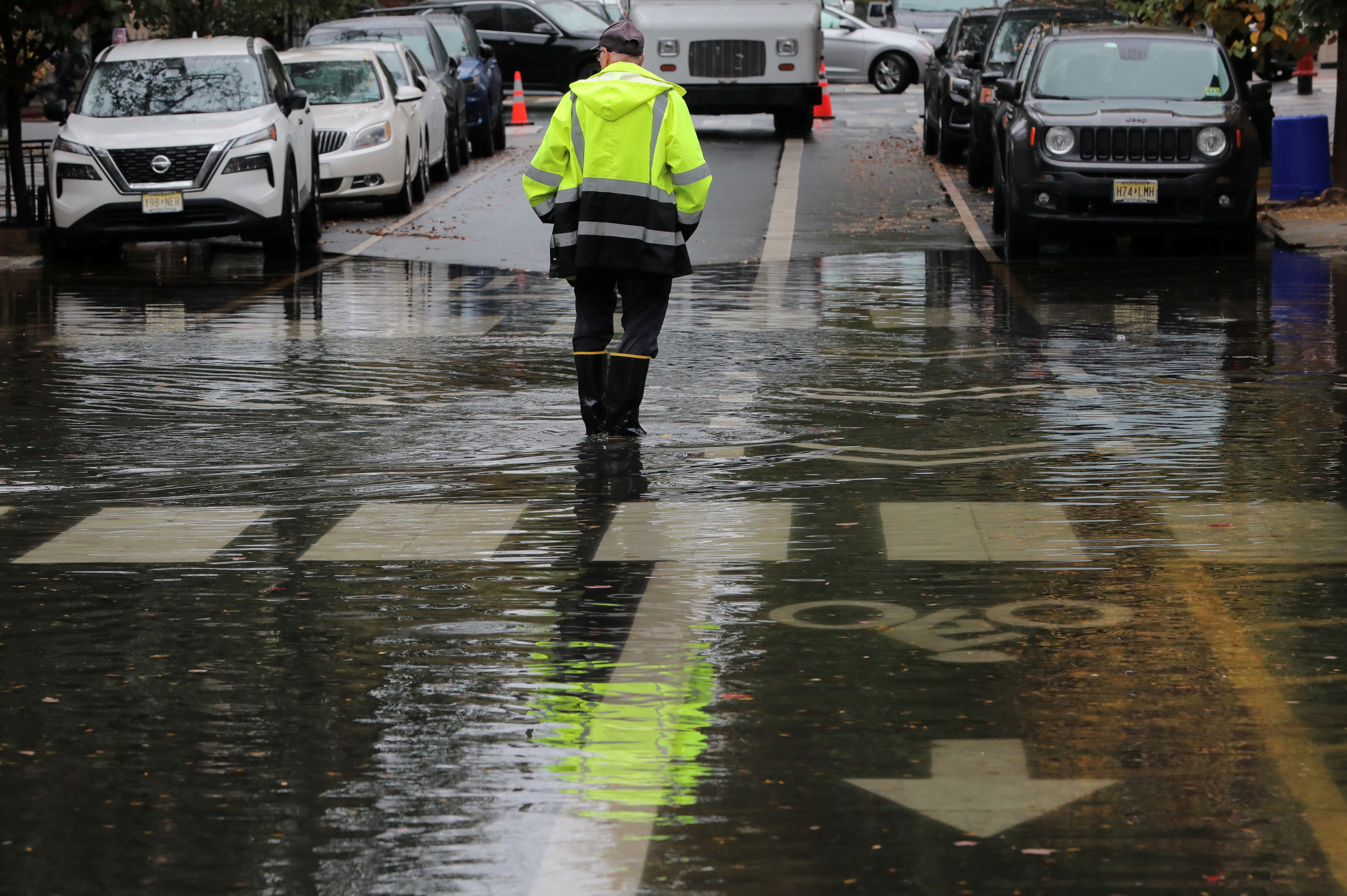 Un hombre permanece de pie en una calle inundada mientras fuertes lluvias llegan al noreste de Estados Unidos, en Hoboken, Nueva Jersey, EE.UU., el 26 de octubre de 2021. (REUTERS/Mike Segar)