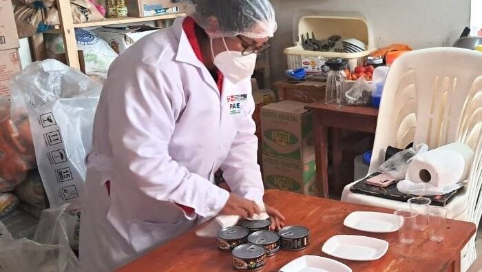 Una especialista del Programa de Alimentación Escolar revisa latas de conserva en Bambamarca tras el hallazgo de presuntas larvas en los alimentos. (Foto: Programa de Alimentación Escolar - PAE)