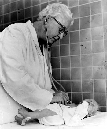 La doctora Virginia Apgar evaluando el estado de salud de un bebé (Magnific)