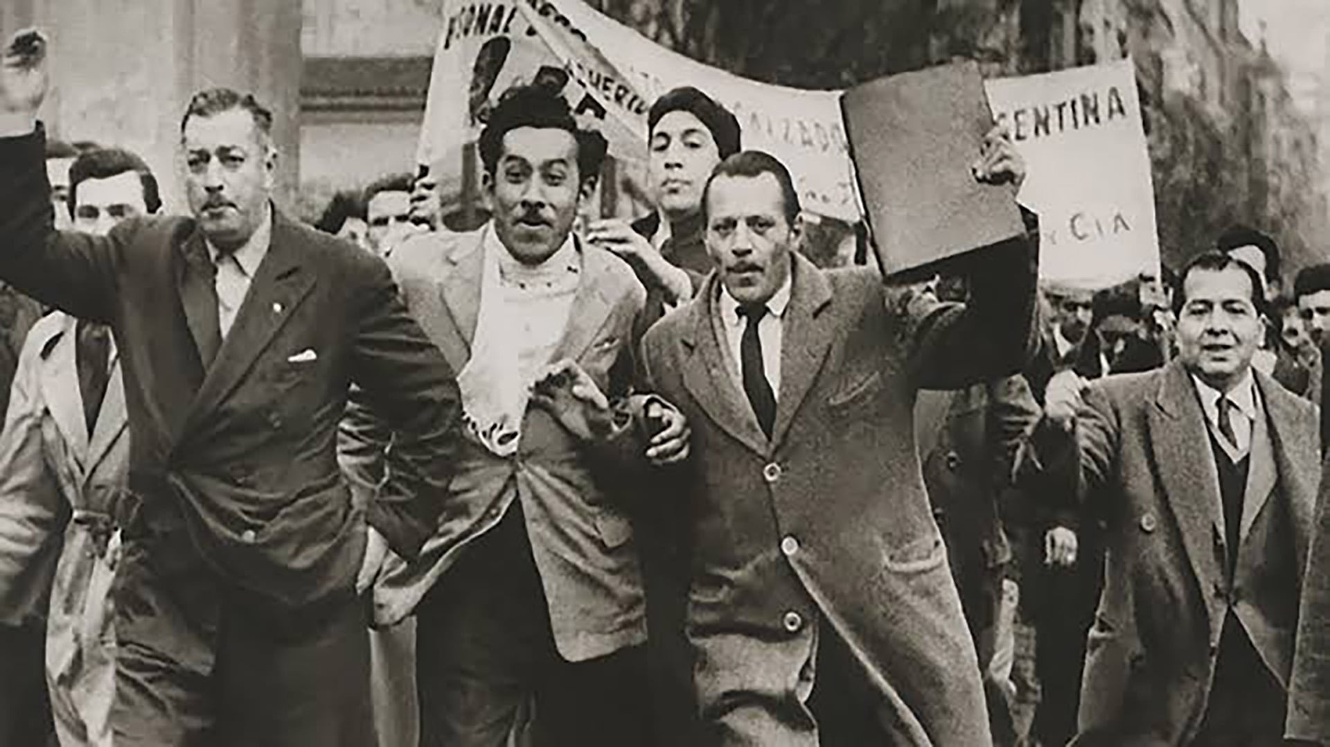 Un grupo de hombres avanza por la calle con pancartas en el marco de la Revolución Libertadora en Argentina