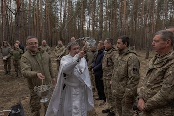 Un capellán bendice a militares de la 33ª brigada mecanizada y cestas de Pascua en la región de Járkov. La tregua de 32 horas redujo los combates, aunque ningún bando la respetó plenamente. (Roman PILIPEY / AFP)