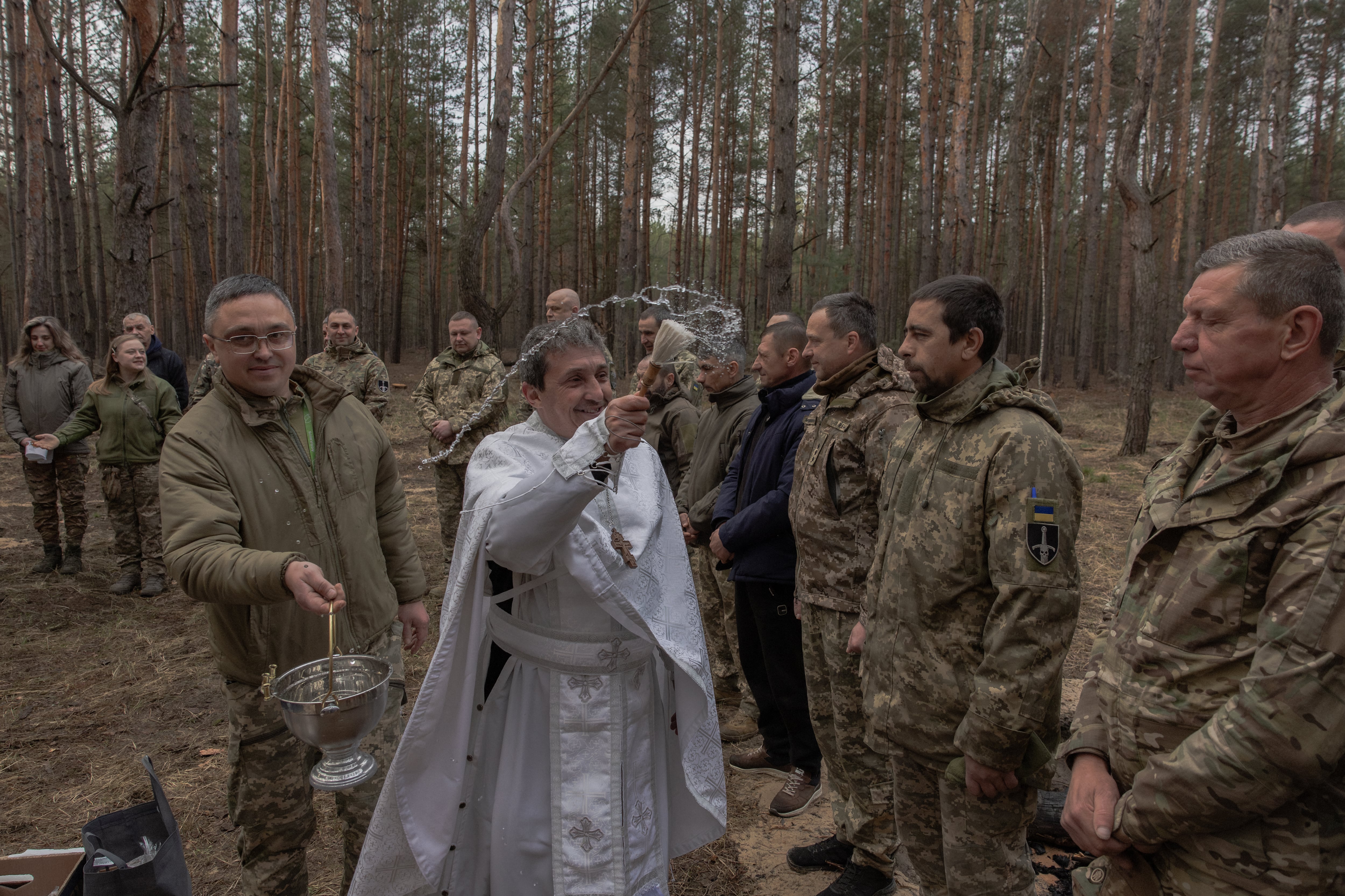 Un capellán bendice a militares de la 33ª brigada mecanizada y cestas de Pascua en la región de Járkov. La tregua de 32 horas redujo los combates, aunque ningún bando la respetó plenamente. (Roman PILIPEY / AFP)