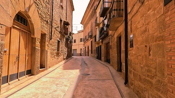 Una calle con casas marrones y estética medieval de piedra.