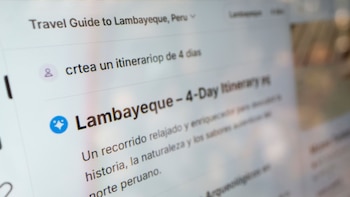 Primer plano de una pantalla de computadora con un "Travel Guide to Lambayeque, Peru", mostrando un itinerario de 4 días y el icono de un asistente virtual