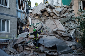 Un rescatista camina sobre los escombros de una casa gravemente dañada tras un ataque ruso contra un barrio residencial en Kiev, Ucrania, el jueves 14 de mayo de 2026 (AP/Evgeniy Maloletka)