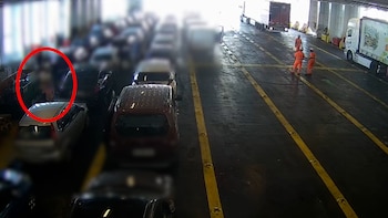 El padre de la menor, a la izquierda de la imagen, sobre la cubierta de vehículos del barco que les sacó de Mallorca (Guardia Civil)