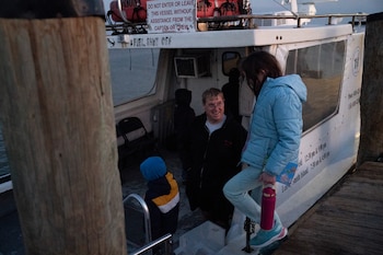 Terry es uno de los dos operadores de ferry que dan servicio a los 200 residentes permanentes de la isla.
Terry welcomes people onto the ferry. (Carolyn Van Houten/The Washington Post)