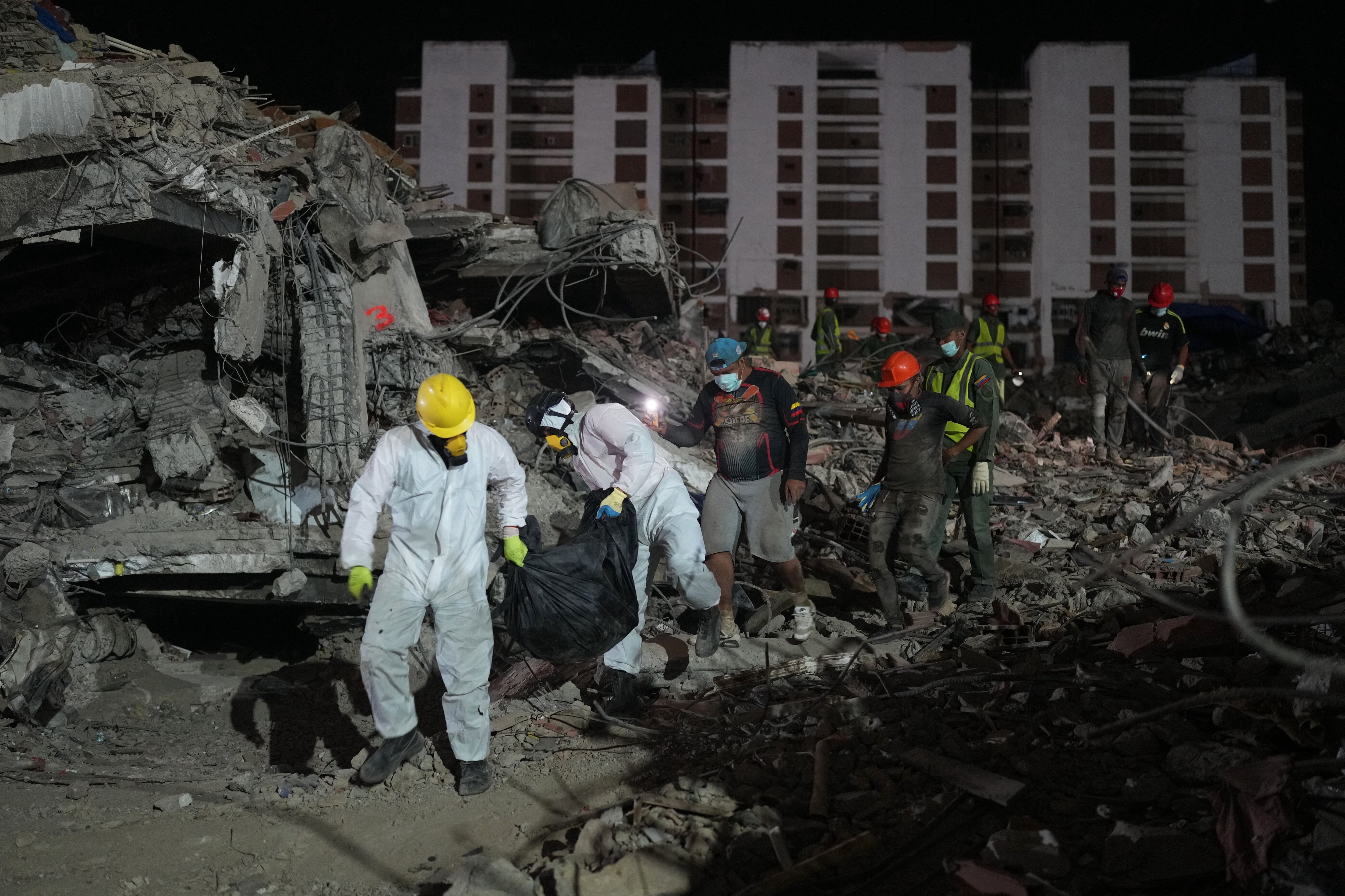 Unas personas transportan un cadáver rescatado de un edificio que se derrumbó a causa de los terremotos en La Guaira, Venezuela, el jueves 30 de julio de 2026 (Foto AP/Ariana Cubillos)