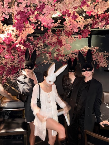 La novia diferenciada del grupo: Lali de blanco entre sus amigas de negro, todas con antifaces de conejo, en uno de los momentos de la noche central de la celebración en Río de Janeiro