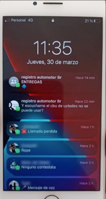 Primer plano de un smartphone blanco con la pantalla de bloqueo activa, mostrando la hora 11:35, fecha y varias notificaciones de WhatsApp