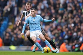 Phil Foden del Manchester City pelea por el balón con Dan Burn del Newcastle en el encuentro del sábado en el Estadio Etihad el sábado 4 de marzo del 2023. (AP Foto/Dave Thompson)
