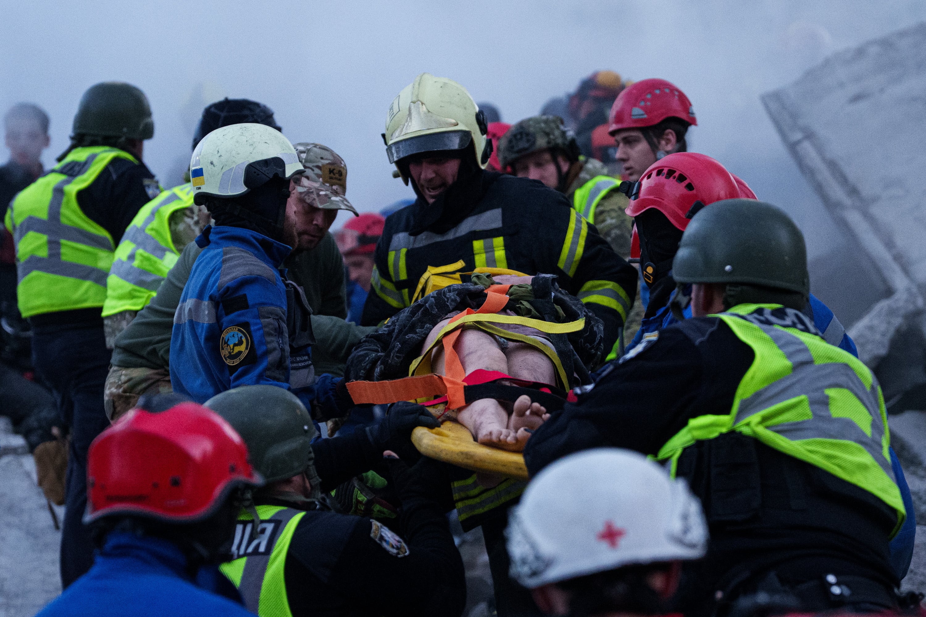 Los equipos de rescate trasladan en camilla a una mujer herida desde una casa gravemente dañada tras un ataque ruso contra un barrio residencial de Kiev, Ucrania, el jueves 14 de mayo de 2026 (AP/Evgeniy Maloletka)