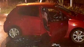 El cuerpo del delincuente junto al Peugeot rojo que manejaba el gendarme y chofer de Uber
