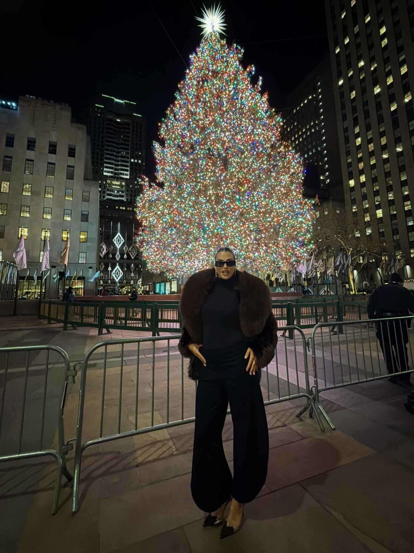 La número 1 posa elegantemente con un abrigo de piel frente al resplandeciente árbol de Navidad del Rockefeller Center en una fría noche festiva en Nueva York (@arynasabalenka)
