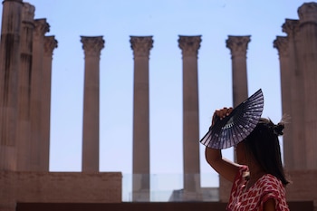 Una viandante intenta protegerse del sol este jueves en Córdoba. (Salas/EFE)