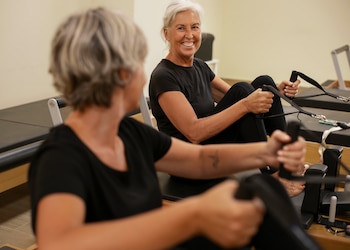 Mujeres practicando pilates con máquinas (Magnific)