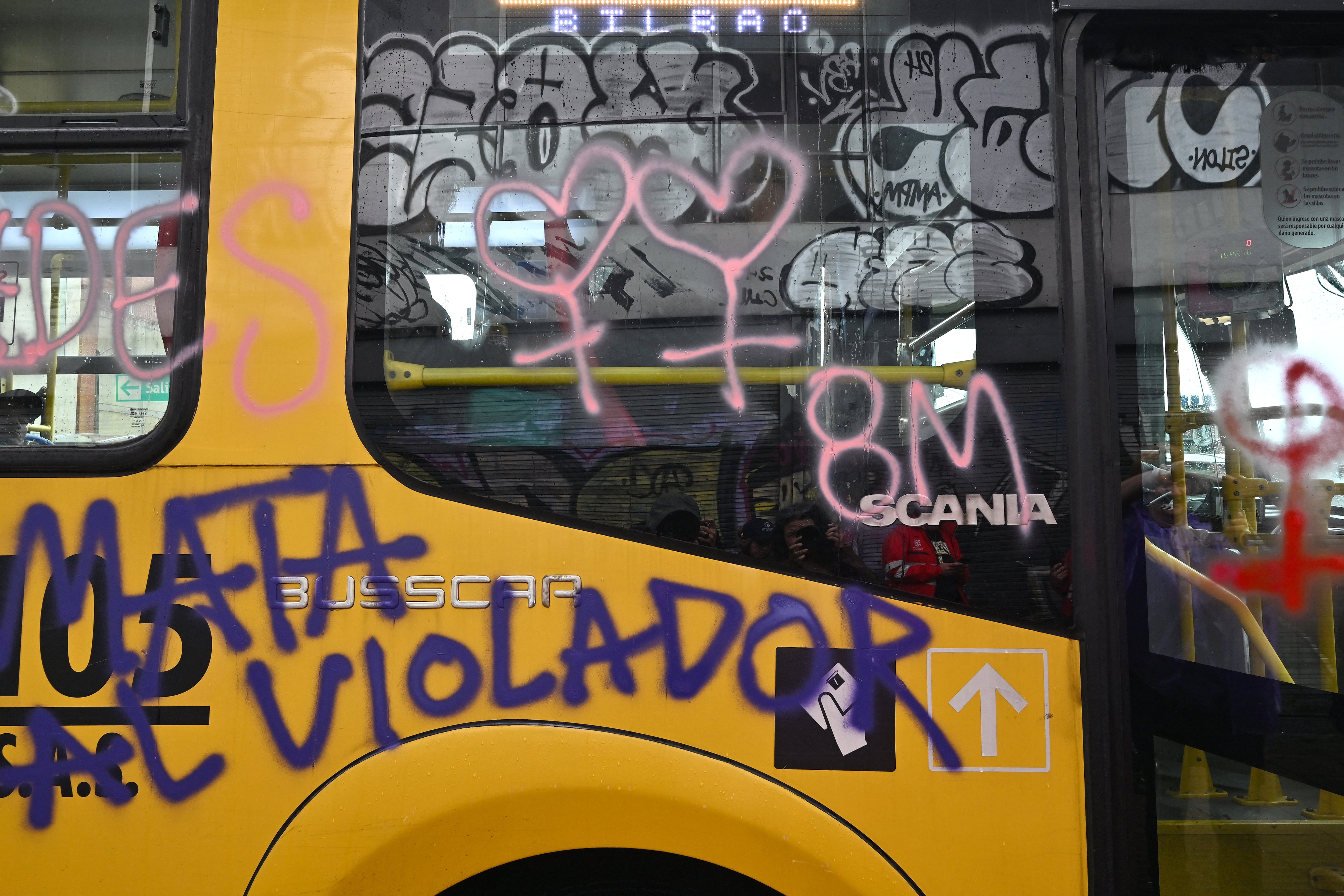 Daños a bienes públicos y privados, como grafitis y pintas en buses y muros, se reportan tras las protestas feministas en Bogotá - crédito AFP