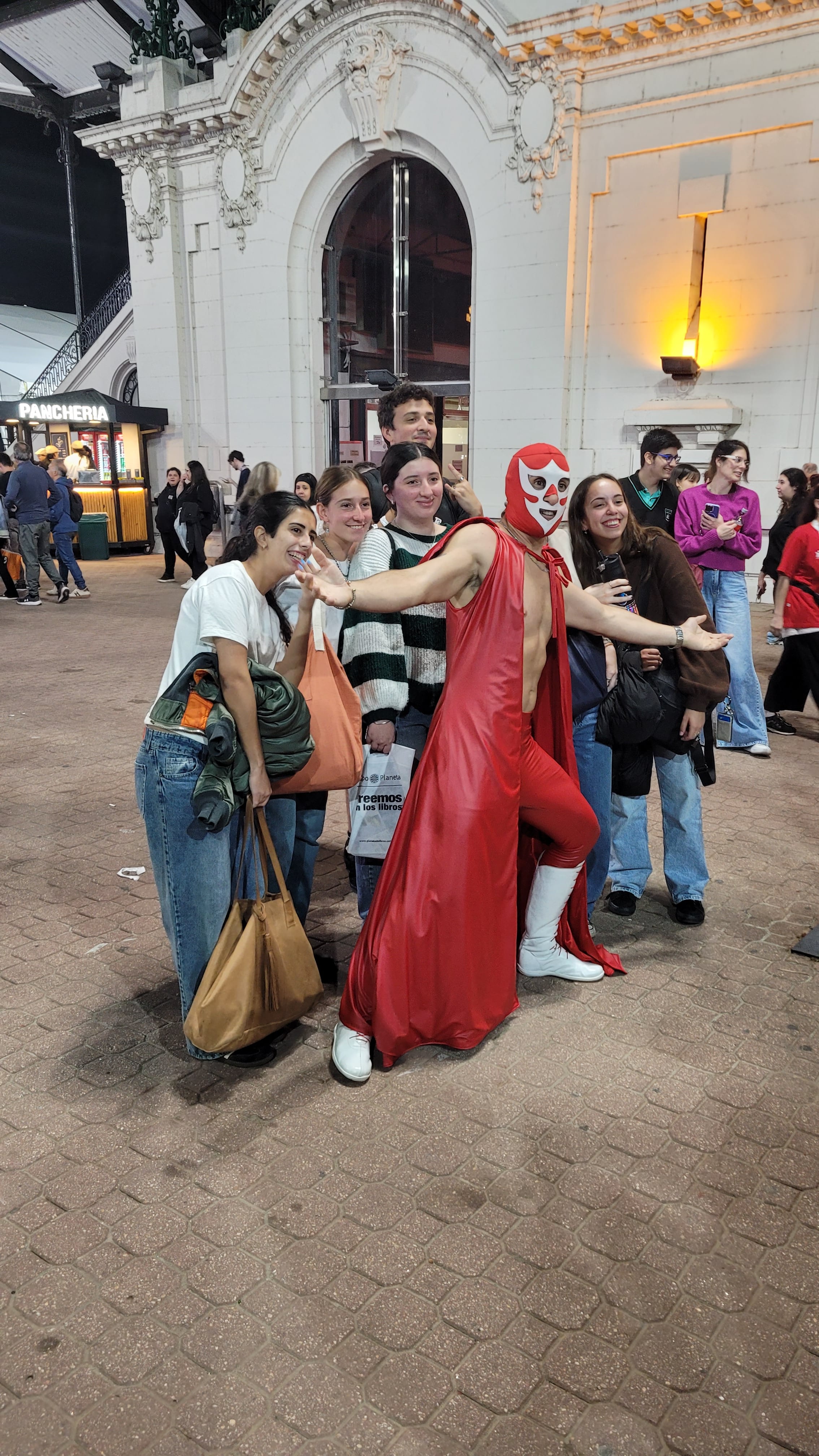 El Caballero Rojo posa con entusiastas visitantes en el marco de La Feria del Libro, captando la atención y generando alegría entre los asistentes.