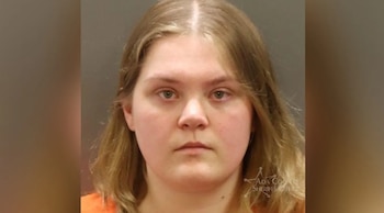Una mujer de cabello rubio, vestida con una prenda naranja, posa de frente ante un fondo oscuro; un logo de la Oficina del Sheriff de Ada County aparece abajo a la derecha